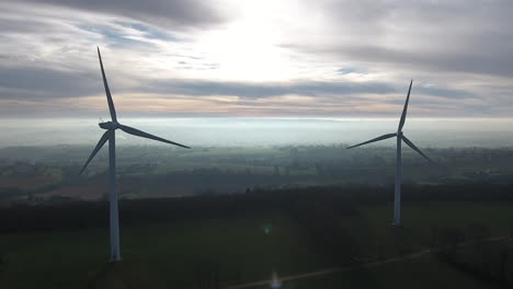 Aerial-back-tracking-wind-turbines-electric-green-power-generator.-Misty-morning